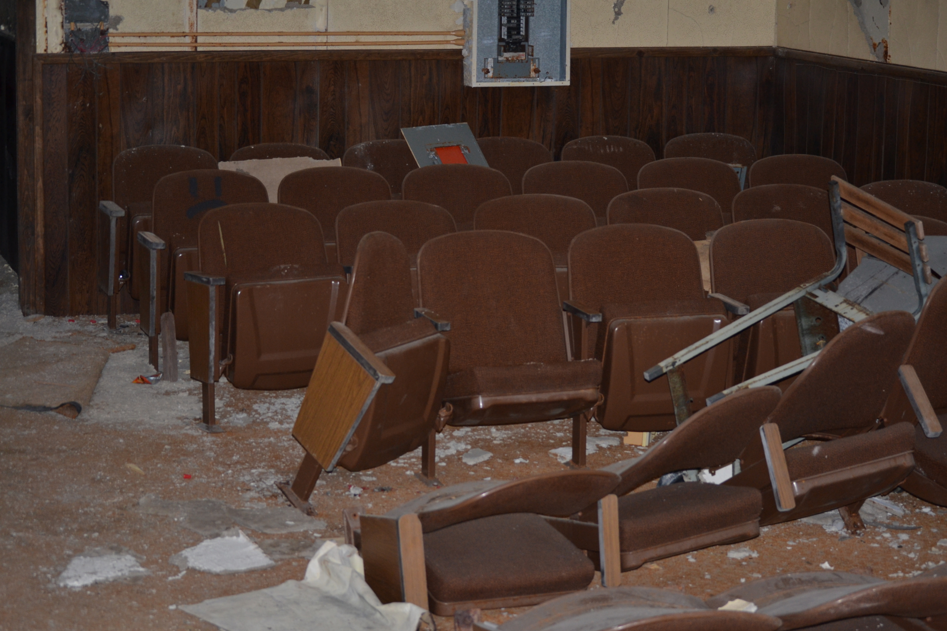 An image of the briefing room in the communications building #20 at Calumet Air Force Station.  Vandalism and destruction is clearly evident.